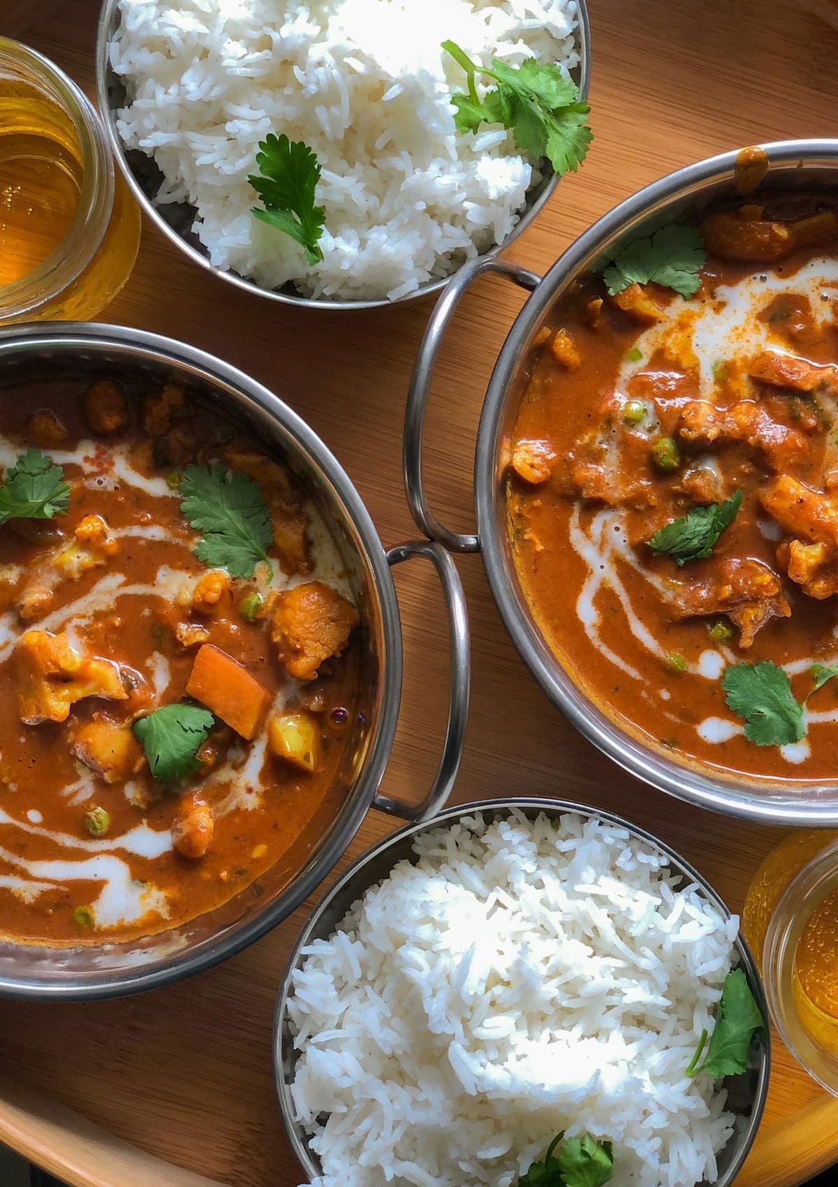 Bowls of rich curry with rice, finished with cream and coriander